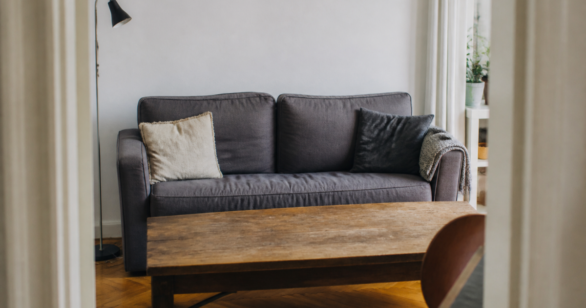 Canape gris face table bois dans petit espace ouvert
