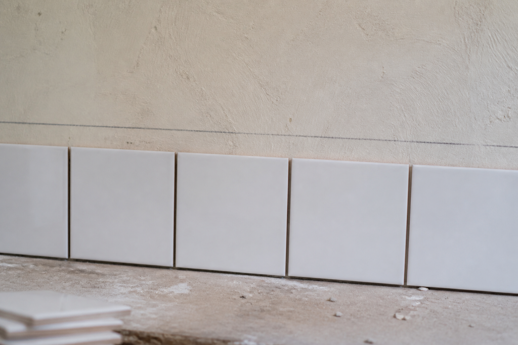 Carreaux blancs alignes sur mur avec trait crayon