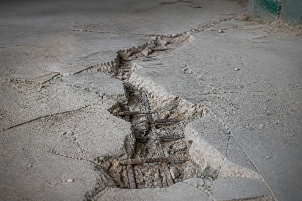 Dalle beton fissurée avec armatures métalliques visibles