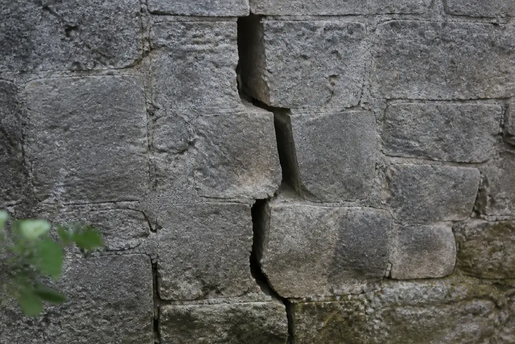 Fissure profonde dans mur pierre ancienne grise