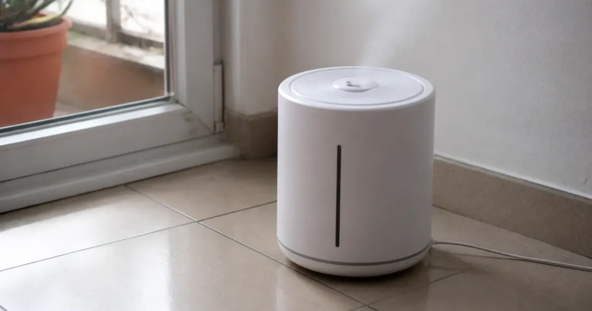 Humidificateur blanc posé sur sol carrelé près fenetre