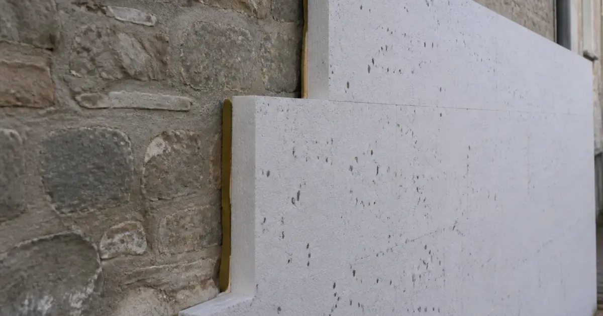 Murs epais en pierre grise avec isolant applique dessus
