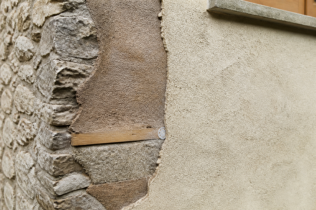 Mur en pierre avec couches isolantes visibles et enduit chanvre