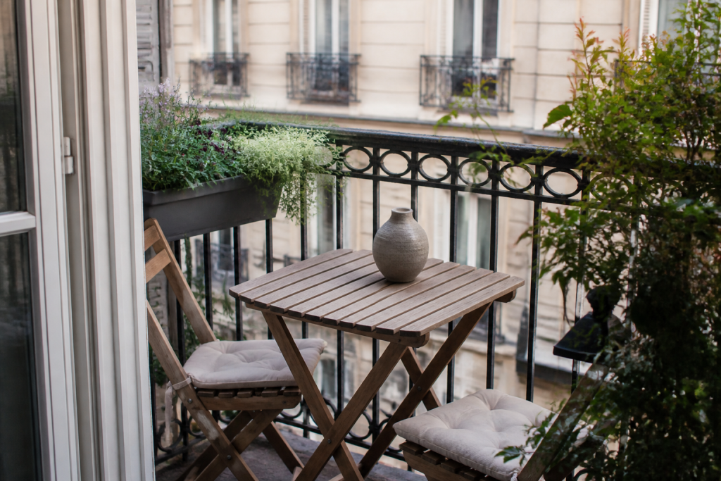 Petit balcon avec chaises pliables et table compacte bois