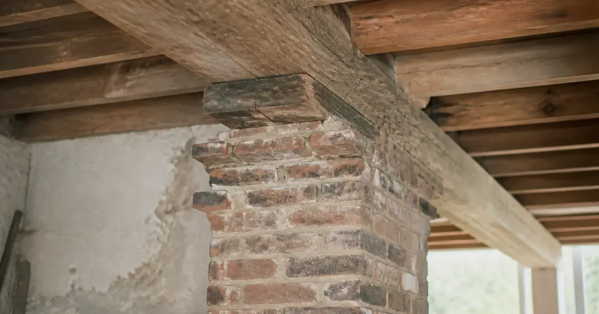 Mur de brique porteur soutenant poutre bois maison ancienne