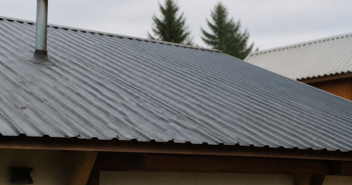 Panneaux metalliques ondules gris couvrant pente toit inclinee maison