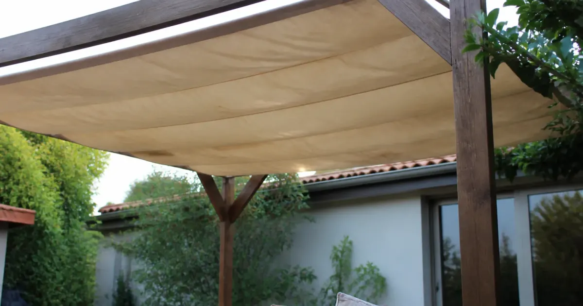 Toile imperméable tendue horizontalement sur structure pergola bois