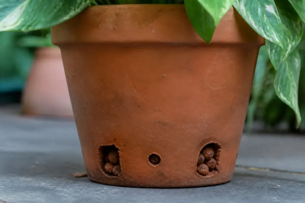 Pot avec trous drainage et billes argile visibles