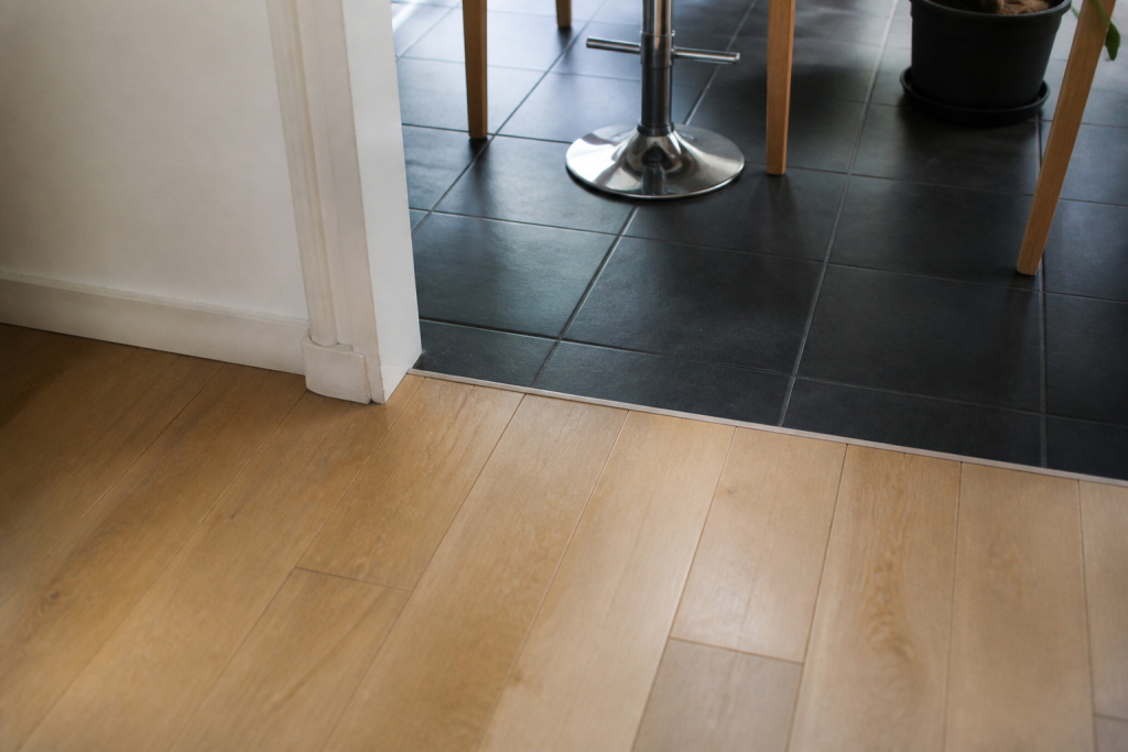 Transition visuelle entre parquet clair et carrelage fonce