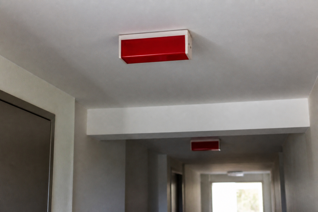Panneaux sortie de secours rouges dans couloir immeuble