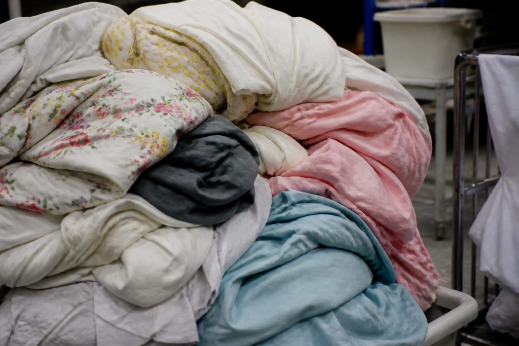 Pile de draps et tissus colorés attendant nettoyage intensif